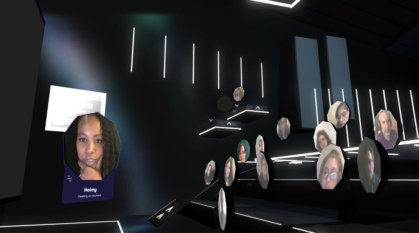 A presenter at mountain workshops in front of a live audience of pods in a blackbox theater